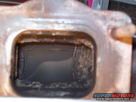 Close-up of an exhaust manifold port with carbon buildup