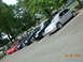 1995 Ford Taurus - A row of sedans, including a silver 1995 Ford Taurus, are parked in a lot with trees overhead.