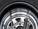 1990 Ford Bronco - Tools are used to remove a tire from a chrome wheel. The tire tread is visible at the top.