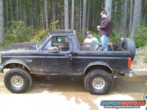 1992 Ford Bronco side view, black, with people in the open top