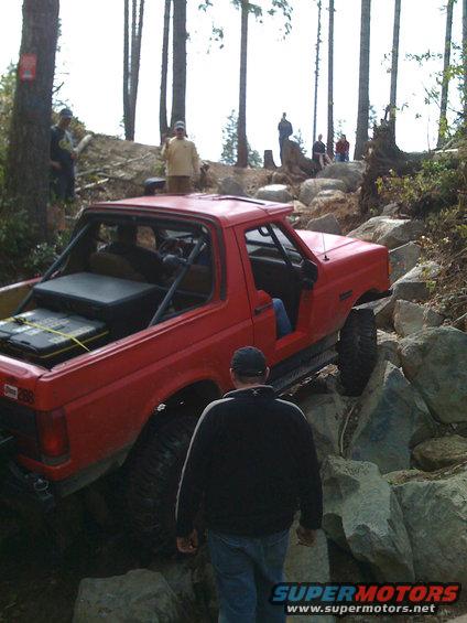 Red 1992 Ford Bronco navigating rocky terrain