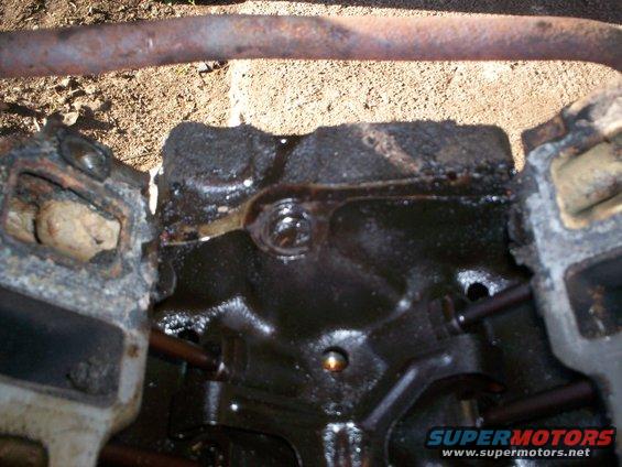 Close-up of an oily engine block with some internal components visible