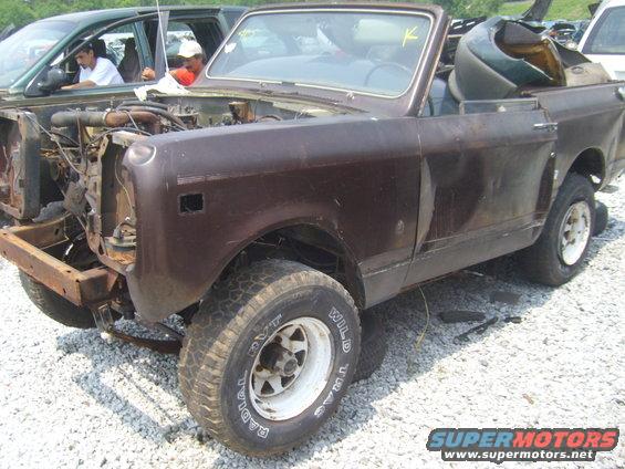 Brown convertible SUV, front end removed, in junkyard