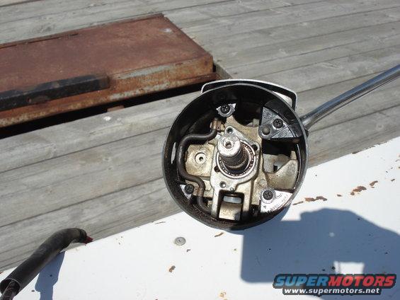 Steering column assembly with exposed gears and bearings, chrome lever extending right, on white surface