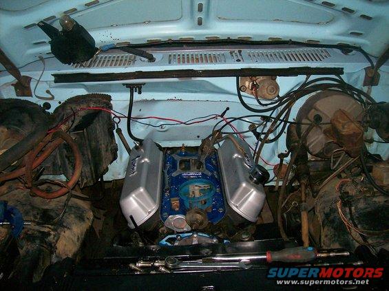 engine bay with blue motor, silver valve covers, and lots of wiring