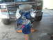 1982 Ford Bronco - A blue V8 engine is mounted on an orange stand, ready for installation into a vehicle.