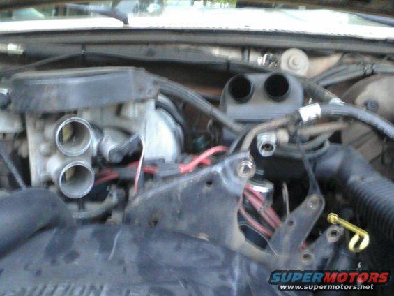 engine bay with carburetor and hoses visible