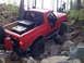 1989 Ford Bronco - Red 1989 Ford Bronco with roll cage and off-road tires navigating a rocky trail.