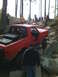 1989 Ford Bronco - A red SUV with a roll cage is shown off-roading over large rocks.