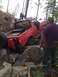 1989 Ford Bronco - A red 1989 Ford Bronco is shown navigating a challenging rocky terrain with several people observing.