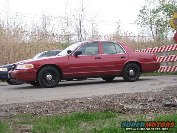 Red sedan parked next to a blue car, with a construction barrier behind it