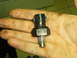 1990 Ford Bronco - A close-up of a single automotive sensor part held in a person's hand.
