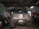 1987 Suzuki Samurai - This heavily modified off-road vehicle is parked inside a cluttered garage with various tools and parts visible.