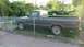 2005 Mazda 6 - An older model pickup truck is parked in a grassy area, partially obscured by a fence.