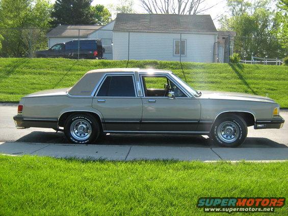Side view of a tan 1988 Mercury Grand Marquis parked on a sidewalk
