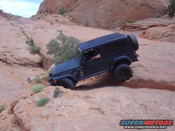 Dark blue Jeep Wrangler Rubicon climbing a rocky incline