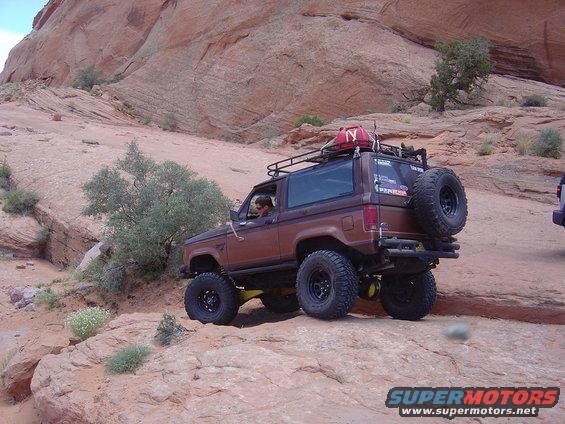 Brown 1986 Ford Bronco II on rocky terrain with spare tire on back