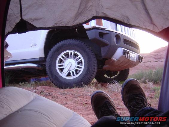 White Hummer H3 parked in desert, viewed from tent interior