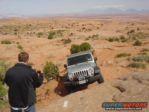 Silver Jeep Wrangler navigating rocky terrain