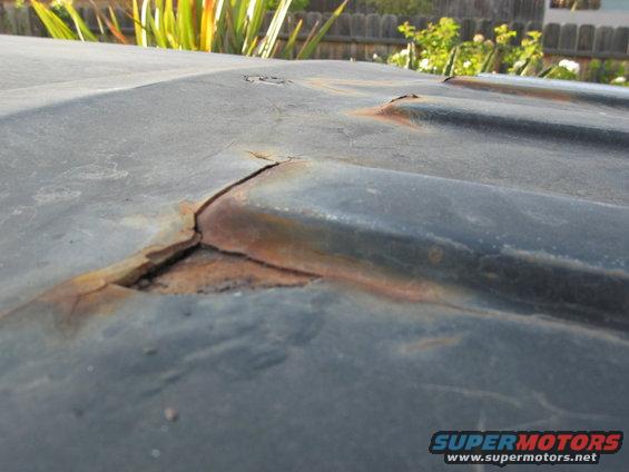 Close-up of a cracked and rusted roof panel, likely from an older vehicle