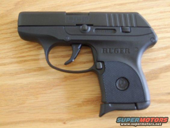 Black Ruger LCP handgun on a wooden surface. The slide has "LCP" engraved on it