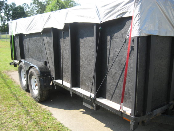 Black trailer with tarp cover, side view