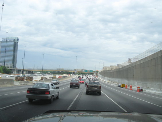 Silver sedan on highway, traffic and construction visible