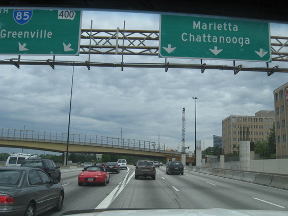 Highway signs for I-85 North and 400 South, pointing to Greenville and Marietta/Chattanooga. Multiple cars and trucks on the road