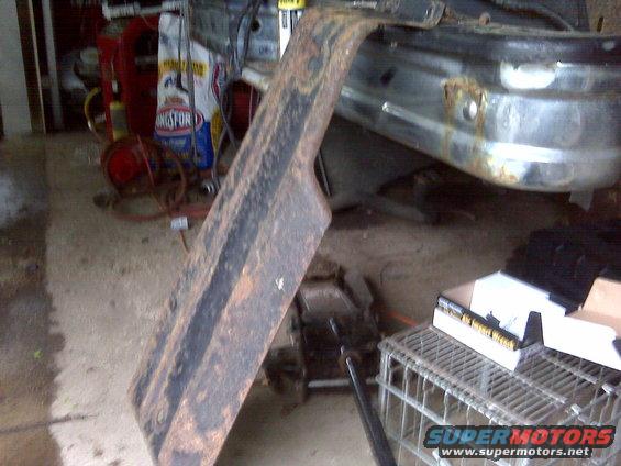 Rusted metal fender flare and chrome bumper with rust spots