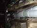 1996 Ford Bronco - Underbody view of exhaust pipes and driveshaft, with Supermotors logo.
