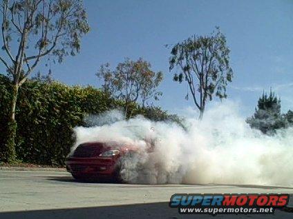 Red 2005 Chrysler PT Cruiser doing a burnout, kicking up a lot of smoke