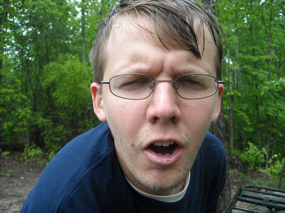 Man with glasses and open mouth in a wooded area
