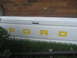 1983 Ford F-250 - The tailgate of a white Ford truck shows the brand name in yellow lettering.