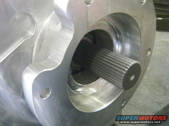 Close-up of a machined metal component with a splined shaft extending from its center