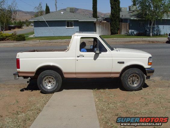Side view of a white 1995 Ford Bronco with brown trim and aftermarket wheels