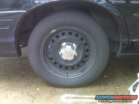 Close-up of a black car's steel wheel and part of the rear fender
