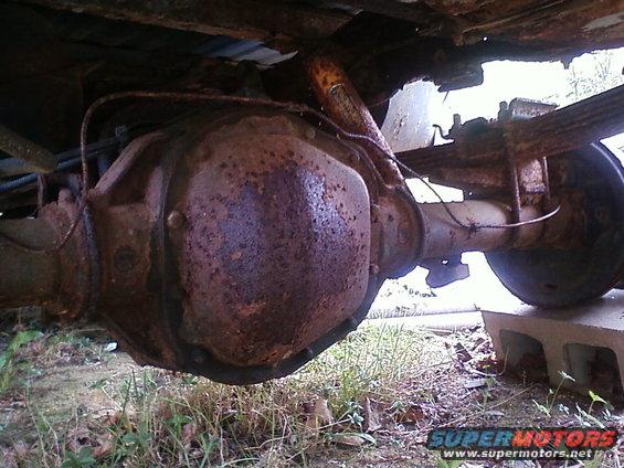 Heavily rusted rear axle assembly and leaf springs of a vehicle, viewed from underneath