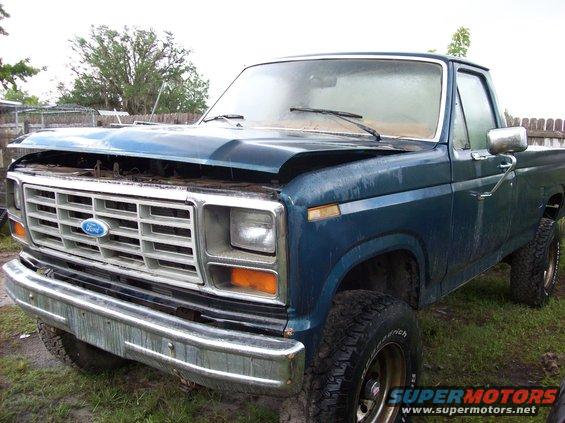 Blue Ford pickup truck with hood open, parked outside