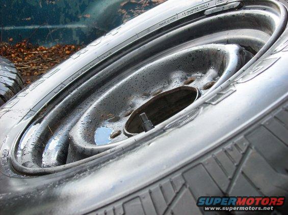 Close-up of a steel wheel and tire with water droplets