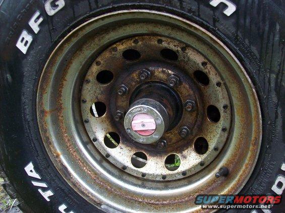 Close-up of a rusty wheel with BFGoodrich Radial T/A tires and a red and silver hubcap