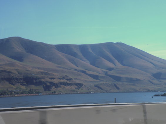Mountainous landscape with a body of water and a clear blue sky