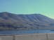 1989 Nissan 300ZX - A scenic view of rolling hills and a wide river under a bright blue sky, captured from a moving vehicle.