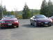 1989 Nissan 300ZX - A purple Ford Probe is parked next to a red convertible with trees in the background.