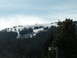 1989 Nissan 300ZX - A view of a snow-covered mountain slope with scattered trees and ski lifts under a partly cloudy sky.