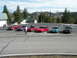 1989 Nissan 300ZX - A collection of sports cars are gathered in a parking lot, with a scenic mountain range visible in the background.