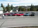 1989 Nissan 300ZX - A group of sports cars are parked in a lot on a sunny day with mountains in the background.