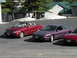 1989 Nissan 300ZX - Three cars are parked in a lot with buildings and trees in the background.