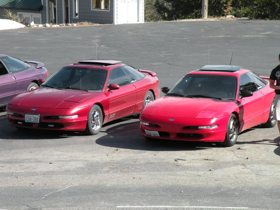 Two red Ford Probes parked in a lot, one with a GT badge