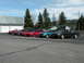 1989 Nissan 300ZX - A row of sports cars, including a black 1989 Nissan 300ZX, are parked outside a building.