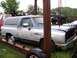 1988 Dodge Power Ram - This 1988 Dodge Power Ram Ramcharger SUV is shown in a yard, suspended by chains, with another truck visible in the background.